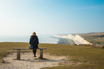 woman sitting on beach and looking at the sea