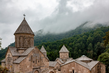 Fototapeta premium The building of the temple on the mountain against the background of the forest and clouds