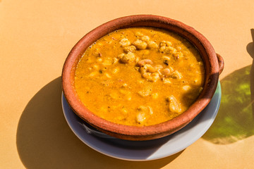 Locro, typical Argentine food, accompanied by bread and a glass of wine, with spoons.