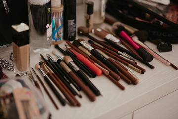 Naklejka premium Make-up brushes on the table. Photo of make-up brushes on the table. Set of brushes, make up application tools laying on a table randomly