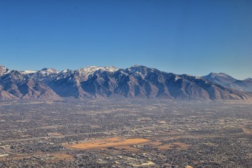 Wasatch Front Rocky Mountain Range Aerial view from airplane in fall including urban cities and the...