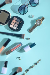 Women's accessories, background from women's cosmetics, with creative color. Creative light. Blue background, vertical frame.