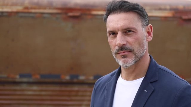 Hombre de mediana edad en primer plano mirando a camara con seguridad