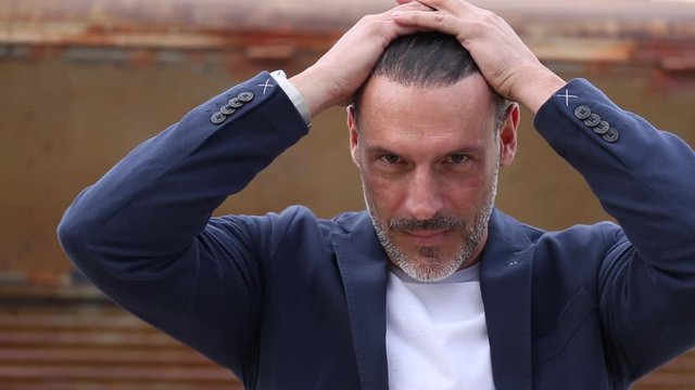 hombre de mediana edad mirando a c&aacute;mara con confianza
