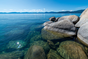 USA, Nevada, Washoe County, Incline Village. The blue expanse of Lake Tahoe with granite boulders...