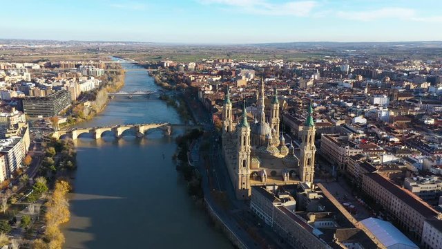 Aerial back traveling over the Ebro river Spain Saragossa Roman Catholic church sunset time