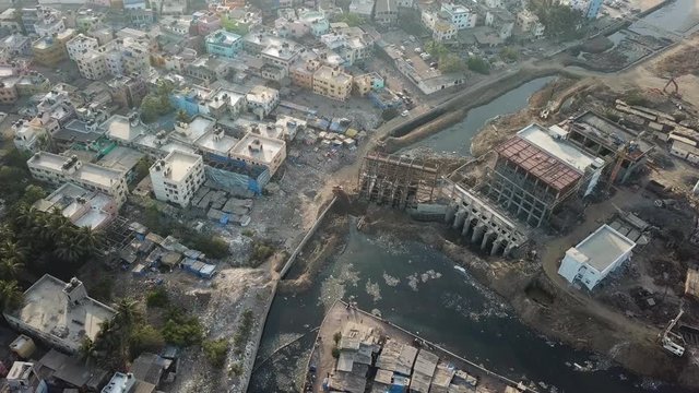 Apocalyptic Aerial View on Mumbai Neighborhood, Dharavi Slum. Dirty River Water and Unfinished Contruction Site