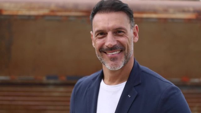 Hombre de mediana edad en primer plano mirando a c&aacute;mara sonriente en 