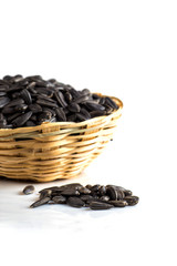 Sunflower Seeds in wooden basket on white background. Helianthus annuus.