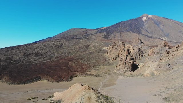Aerial view footage of volcano Teide, Tenerife, Canary islands, Spain. Beautiful panorama with volcanic landscape, the peak of Teide, colorful rocks and solidified lava flows. 4K cinematic drone video