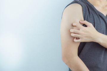 Close up man scratching his itchy arm with allergy rash by hand on white background. Healthcare, skin problem and medical concept.