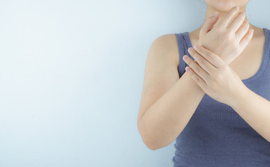 Closeup woman holds her wrist pain on white background. Health care and medical concept.