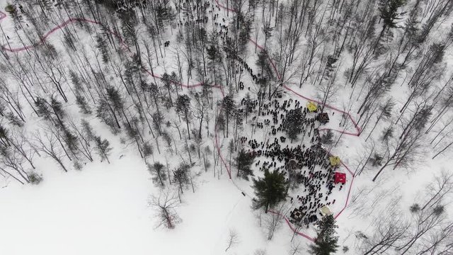 Winter party in the woods in Traverse City Michigan 4K drone shots over forest and open woods in winter snow covered scene party around a fire