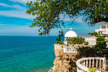 Beautiful white gazebo and tropical flower garden on Caribbean ocean background, summer mountain view , Sosua, Puerto Plata, Dominican Republic