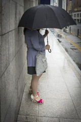 woman putting up an umbrella in the rain and waiting for man