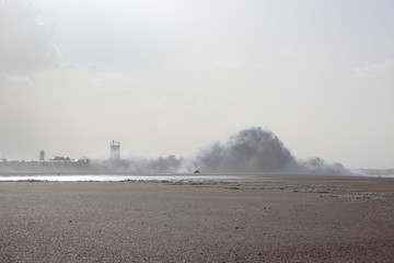 Lighthouse with cloudy sunny sky at the beach