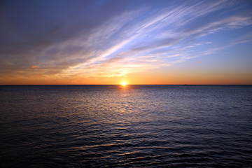 Fototapeta na wymiar Sunrise at the sea with blue cloudy sky