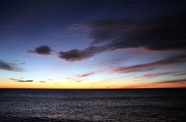 Sunrise at the sea with blue cloudy sky