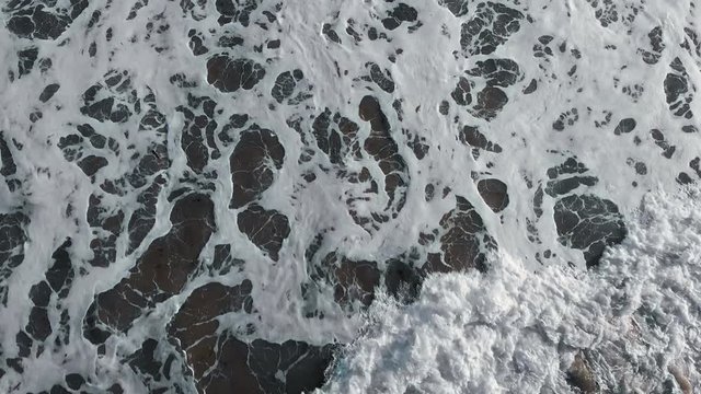 Big Waves rolling from above. Top down close-up 4K drone view on blue ocean, breaking waves, whitewash. Sunny morning over the sea. Bali island, Indonesia. ProRes