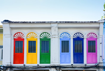 colorful wooden arched window on white cement wall in chino Portuguese style at Phuket old town,...