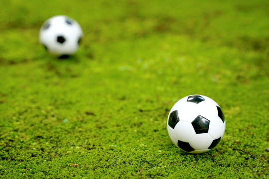 2 balls of football (soccer) on green background. Sport concept. Can be use decorate for advertising icon or brochure. Copy space. 