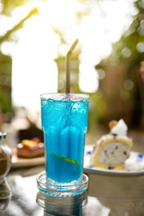 Italian soda, blueberry soda on a clear glass table.