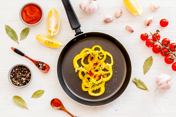 Cooking food concept. Pasta on frying pan near spices and vegetables on white background top-down