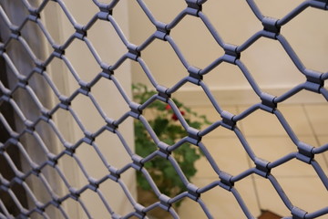 Fototapeta premium Light blue metal wire door fence