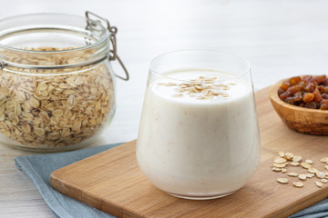 Vegan oatmeal smoothie with banana in glass jar on the light background. Healthy food.