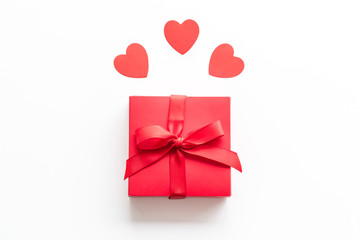 Gift to a sweetheart on Valentine's Day. Red present box near hearts on white background top-down copy space