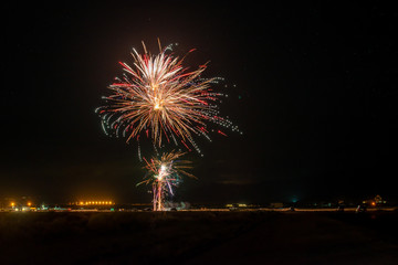 USA, Nevada, Esmerelda County, Hawthorne. A burst of red fireworks below a starry desert night sky.
