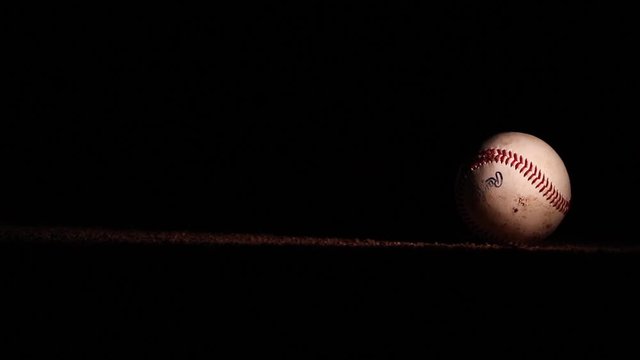 Dirty Baseball Drops Onto Field at Night