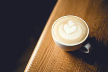 Cup of cappuccino on wooden table.