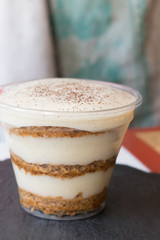Handmade process of making an Italian tiramisu cake at home. Ready cake sprinkled with chocolate