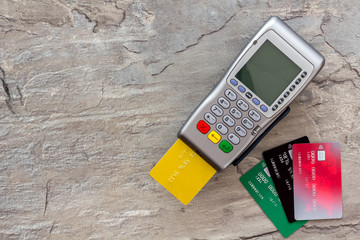 Pay by card. Plastic card inserted in terminal on grey stone background top-down copy space