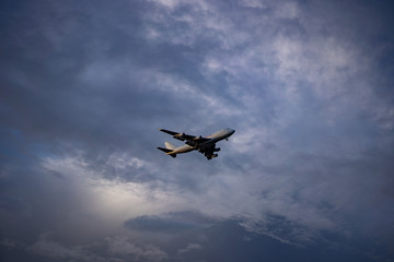 Fototapeta na wymiar Airplane preparing for landing amongst clouds at sunset