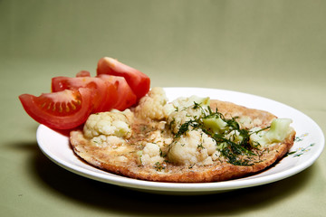 Cooking. Frying Broccoli, eggs and peaces of red tomato on the plate