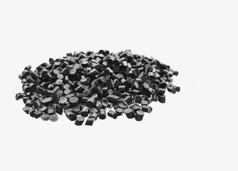 Close-up of black plastic polymer granules on white background