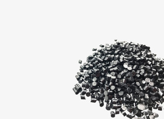 Close-up of black plastic polymer granules on white background