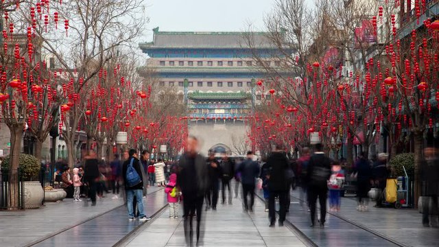 BEIJING/CHINA - MARCH 18 2019: Chinese people wander along Beijing Qianmen street timelapse zoom out