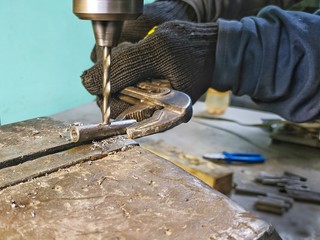Drilling machine workpiece. Worker drills a part on a machine.
