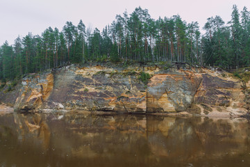 Fototapeta na wymiar City Cesis, Latvia. Red rocks and river Gauja. Nature and green trees in winter.