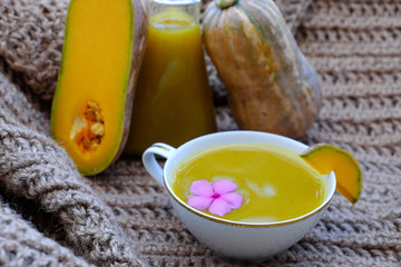 Close up cup of winter squash milk, pumpkin raw material