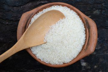 Scoop rice by using a ladle in a clay pot