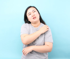 Portrait  Asia woman feel very itchy arm, on blue background in studio.