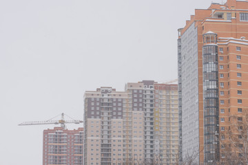 Winter. Snowfall in the city. Houses are covered with snow.