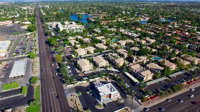 Aerial drone photography looking down desert city traffic and homes pulling backwards