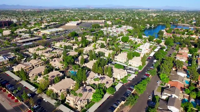 Aerial drone photography over homes on a small lake. Slow moving drone footage over a nice community