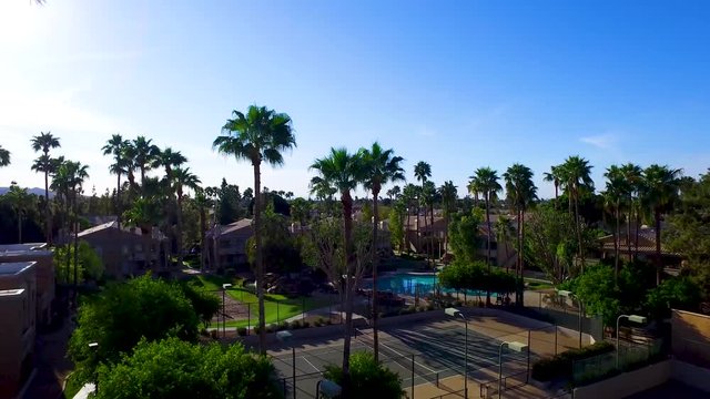 Aerial drone photography ascending over tennis courts and pool on a resort