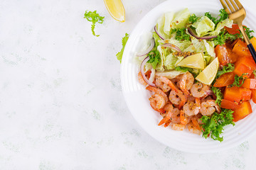 Fruit salad with fried prawns / shrimps, persimmon, red onion and lettuce in white bowls. Appetizers, snack, brunch. Healthy food. Top view, overhead, copy space